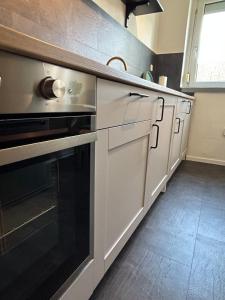 a kitchen with white cabinets and a black oven at Monteurwohnung I Wi-Fi I Nähe Boxberg & Schwarze Pumpe in Burgneudorf