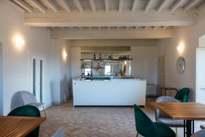 a bar in a restaurant with green chairs and tables at Dimora Storica Antica Grancia in Rapolano Terme