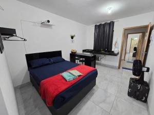 a bedroom with a bed with a red blanket at Flat completo 12 minutos do centro com lojas variadas in Aparecida de Goiania