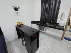 a black desk in a room with a window at Flat completo 12 minutos do centro com lojas variadas in Aparecida de Goiania