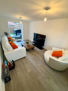 a living room with two white couches and a flat screen tv at Detached 4BR House - Private Garden, Garage & Parking - Perfect for Long Stays, Families, Contractors in Canterbury