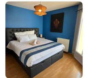 a blue bedroom with a bed with a dog laying on it at Villa familiale piscine proche de Paris in Antony +6 photos