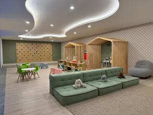 ein Wohnzimmer mit einer grünen Couch und einem Tisch in der Unterkunft Encanto Roma con RoofPool, Coworking, Gym y PlayRoom in Mexiko-Stadt