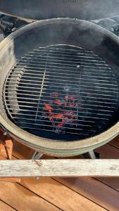 a grill with red meat cooking in it at Villa familiale piscine proche de Paris in Antony