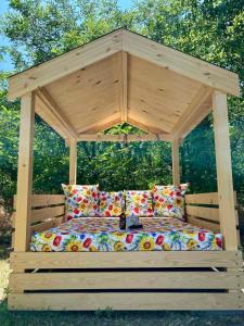 a wooden gazebo with a bed with a canopy at Varázslakos Tanya in Soltvadkert