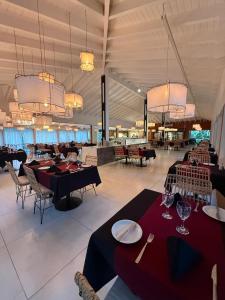 a dining room with tables and chairs and chandeliers at La Reserva Virgin Lodge in Puerto Iguazú