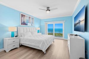 1 dormitorio con paredes azules, 1 cama y ventana en Versailles Sur La Mer 1D, en Melbourne Beach 34 fotos más
