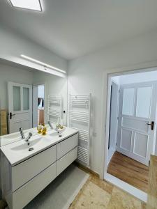a white bathroom with a sink and a mirror at Mountain View House Brasov in Braşov +36 photos