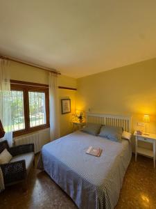 a bedroom with a bed and a chair and a window at Villa Solana in La Drova