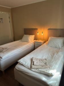 two beds sitting next to each other in a bedroom at SteneBo in Stenestad