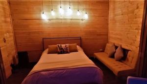 a bedroom with a bed and a bench in it at Biofilia Colombia in Tausa Viejo
