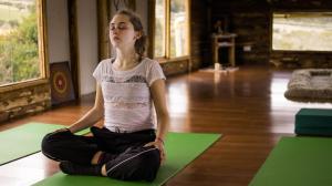 a girl sitting in a yoga pose on the floor at Biofilia Colombia in Tausa Viejo