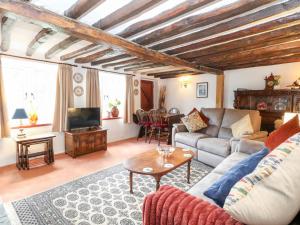 een woonkamer met een bank en een tafel bij Hollyhedge Cottage in Briston