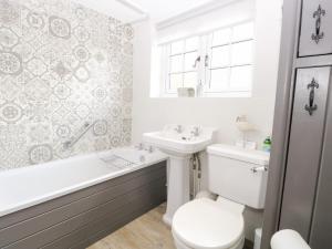 een badkamer met toilet, wastafel en bad bij Hollyhedge Cottage in Briston +33 foto's