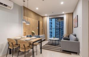 a dining room with a table and chairs and a couch at StayLocal Apartment in Long Bình