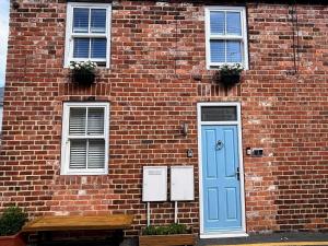 ウィットビーにあるThe Store Roomsの青いドアと窓のあるレンガ造りの建物
