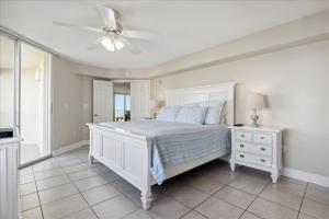 a bedroom with a white bed and a ceiling fan at Michelina 406 in Cape Canaveral +45 photos