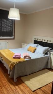 ein Schlafzimmer mit einem Bett mit zwei Handtüchern darauf in der Unterkunft Katxutxa El corazon de Galicia in Lalín