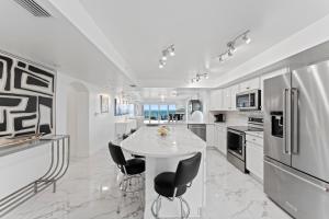 a white kitchen with a table and chairs at Flores Ocean Suites 402 in Cape Canaveral