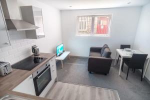 ブラックバーンにあるContemporary 1BED Apartment in Central Blackburnのソファとテーブルのあるキッチンとリビングルーム