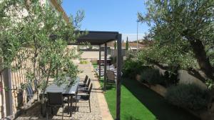a patio with a table and chairs under a canopy at Escape to a spacious retreat with garden in Avinyonet de Puigventós