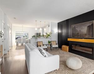 a living room with a white couch and a fireplace at Entire Home - backyard oasis, indoor fireplace, Huge TV in Fort McMurray