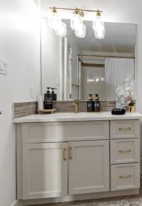 a bathroom counter with a sink and a mirror at Entire Home - backyard oasis, indoor fireplace, Huge TV in Fort McMurray