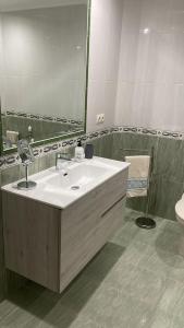 ein Badezimmer mit einem weißen Waschbecken und einem Spiegel in der Unterkunft Katxutxa El corazon de Galicia in Lalín + 4 Fotos