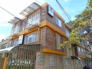 un edificio de ladrillo marrón con un cartel. en Casa Santa Isabel, en Bogotá