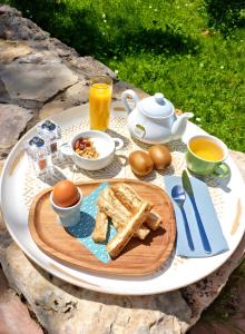 a table with a breakfast of eggs bread and coffee at L'eden Provençal in Les Saquetons