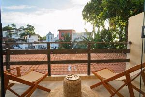 a balcony with two chairs and a view of a city at Boho Loft Escape Pool Balcony & Champagne in Cayru