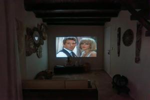 a living room with a tv showing a man and a woman at Morro de São Paulo - Boho Loft Escape Pool Balcony & Champagne in Cairu