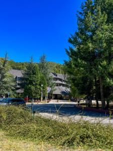 a street with a parking lot with a building and trees at Hotel Junior in Kopaonik