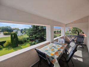 a dining room with a table and a large window at Apartments Norma in Funtana