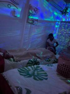 a woman sitting on a bed in a room at Massaji&SPA-Massage Spa in Oslob