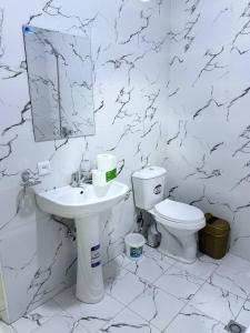 a white bathroom with a sink and a toilet at City Center Apartment "Afsona mall" in Irvadan +7 photos
