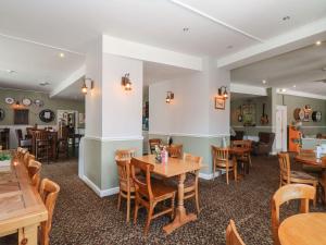 a dining room with wooden tables and chairs at Manorcombe 1 in Gunnislake