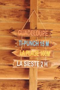 un cartello di legno appeso a una parete di legno di Kaz Ti Bali Bungalow Jacuzzi a Saint-François
