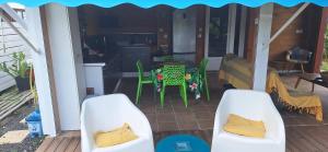 un patio con tavolo e sedie su un ponte di Kaz Ti Bali Bungalow Jacuzzi a Saint-François