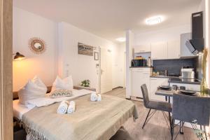 a room with a bed and a table and a kitchen at Altstadt Apartment am Breiten Turm in Delitzsch +14 photos