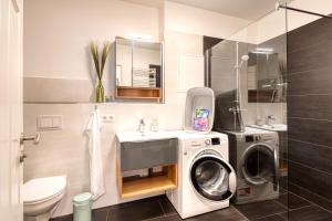 a bathroom with a washing machine and a sink at Altstadt Apartment am Breiten Turm in Delitzsch
