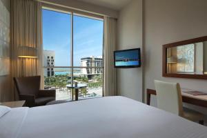 a hotel room with a bed and a large window at Yas Plaza Circuit by IHG in Abu Dhabi