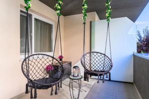 two chairs and a table on a porch at OCCO by the Mountains in Braşov