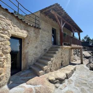 a stone building with a door and a staircase at Gardunha Stone in Louriçal do Campo