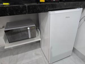 een magnetron en een koelkast in de keuken bij Flat completo 14 minutos do centro do Buriti Shopping in Aparecida de Goiania