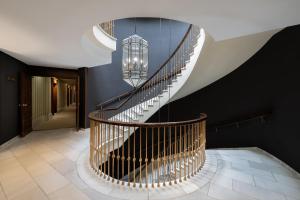 a spiral staircase in a house with a chandelier at RL Ciudad de Úbeda in Úbeda