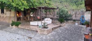 a patio with white furniture and an umbrella at Casa Rural Alma de Campo in Collado de Gil +11 photos