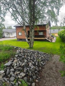 a house with a tree and a pile of rocks at Close to the Sea, Scandi Style house in Porvoo