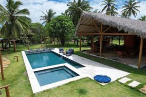 an image of a swimming pool in front of a house at Chalé Iracema – Atins-MA in Atins