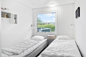 two beds in a room with a window at 30138-Ulfborg-Bellisvej-513 in Vang